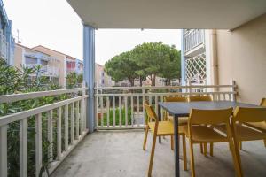 d'une terrasse avec une table et des chaises sur un balcon. dans l'établissement T2 Tamaris Piscine Proche Plage Palavas, à Palavas-les-Flots