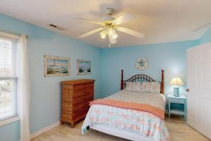um quarto com uma cama e uma ventoinha de tecto em Home by the Sea em Surf City
