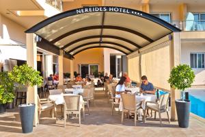 a restaurant with people sitting at tables in a building at Nereides Hotel in Karpathos