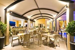 a restaurant with tables and chairs in a room at Nereides Hotel in Karpathos Town