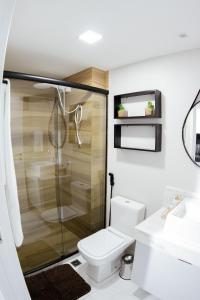 a bathroom with a shower and a toilet and a sink at Unity - Cabo Branco in João Pessoa