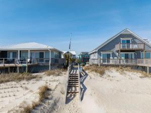 a row of houses on the beach next to the sand at Home by the Sea in Surf City