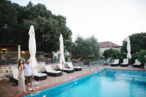 mężczyzna i kobieta stojący obok basenu w obiekcie Heritage Hotel & Estate Raznjevica Dvori AD 1307 w mieście Polača