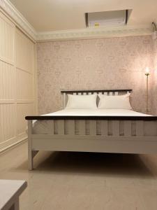 uma cama grande num quarto com uma parede em Bright Starry Hostel -Vacation in Donggang em Donggang