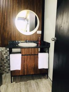 bagno con lavandino e specchio di Hotel & Golf Isak Aeropuerto a Rionegro