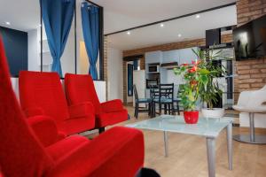 a living room with red chairs and a table at Domaine Evasion in Ittlenheim