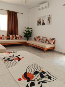 a living room with two couches and a rug at Sawsen Ghar el melh in Ghār al Milḩ