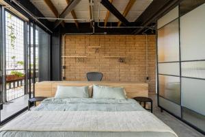um quarto com uma cama e uma parede de tijolos em Buenos Aires LOFT by Pardela, Colonia Americana em Guadalajara