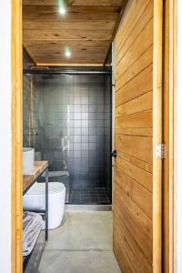 uma casa de banho com um chuveiro, um WC e uma porta de vidro em Buenos Aires LOFT by Pardela, Colonia Americana em Guadalajara