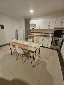 cocina con mesa de madera y armarios blancos en Select Inn en Río Grande