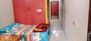 Cette chambre comprend un lit et une porte rouge. dans l'établissement Manchaman home stay, à Ujjain