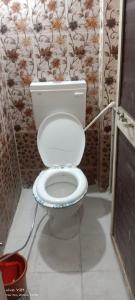a bathroom with a white toilet in a room at Manchaman home stay in Ujjain