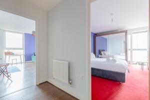 a bedroom with a white bed and a red rug at Quirky 1BD Flat wGym & City Views Dalston! in London