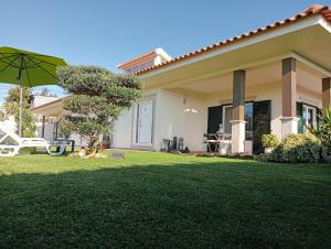 a house with a lawn with a green yard at TERRENO DAS MIMOSAS in Aveiro