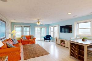 a living room with orange furniture and a flat screen tv at Home by the Sea in Surf City