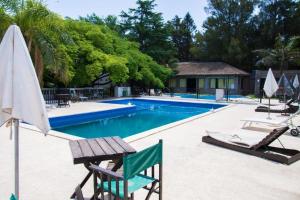 a swimming pool with two chairs and an umbrella at Rio Victoria in Victoria