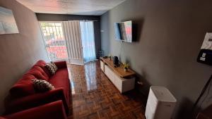 Yanira's house في سانتا آنا: غرفة معيشة مع أريكة حمراء ونافذة