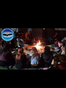 un groupe de personnes assises devant un incendie dans l'établissement Mi Quincho Cañuelas, à Cañuelas