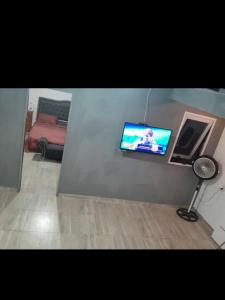 ein Wohnzimmer mit einem TV an der Wand in der Unterkunft Mi Quincho Cañuelas in Cañuelas