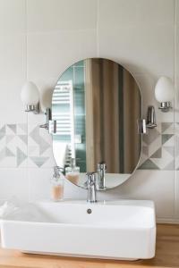 uma casa de banho com um lavatório branco e um espelho. em Maison chaleureuse 3* à deux pas de la plage em Gujan-Mestras