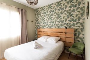 um quarto com uma cama e uma cadeira verde em Maison chaleureuse 3* à deux pas de la plage em Gujan-Mestras