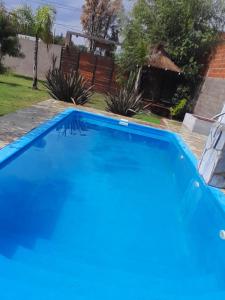 una gran piscina azul en un patio en Mi Quincho Cañuelas en Cañuelas