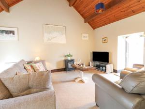a living room with a couch and a tv at Dove Cottage in Leek