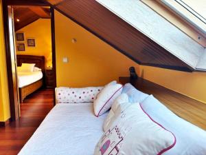 a bed in a room with a slanted at Holibai, Vila Arume, Sofisticación y Confort cerca de Baiona in Pontevedra