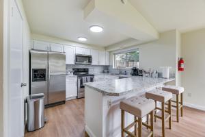 a kitchen with white cabinets and stainless steel appliances at Olympia Home with Deck about 7 Mi to Amtrak Train! in Olympia