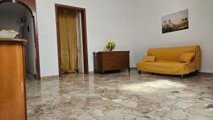 een woonkamer met een gele bank en een tafel bij Reggia di Poseidone in Taviano
