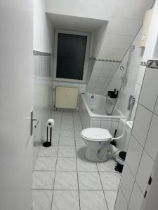 a bathroom with a toilet and a bath tub at Über den Dächern von Bochum in Bochum