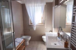 baño con lavabo y aseo y ventana en Novatek Apartment B&B, en Chieti