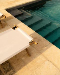 een zwembad met een tafel naast een zwembad bij Dimore del Cisto in Santa Maria al Bagno