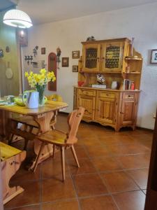 uma cozinha com uma mesa e uma mesa e cadeiras em Residenze Bucaneve - Casa Costa em Tonezza del Cimone