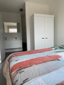 - une chambre avec un grand lit et une armoire blanche dans l'établissement Residentie Nivaria Zeebrugge, appartement met 1 slaapkamer aan de jachthaven, à Zeebruges