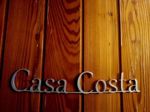 a sign on the side of a wooden wall at Casa Costa in Tonezza del Cimone