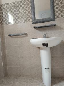 a bathroom with a white sink and a mirror at Sawsen Ghar el melh in Ghār al Milḩ