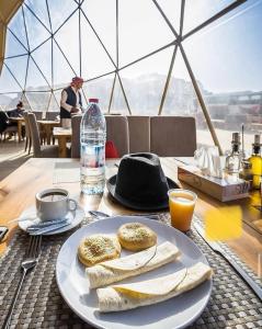 a table with a plate of bread and a bottle of water at RUM ROYAL BUBBLES lUXURY CAMP in Wadi Rum