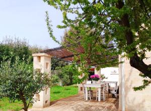 een patio met een tafel en een pergola bij La dimora di nonna Giuliana in Ostuni