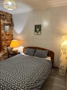 sypialnia z łóżkiem z czarno-białą kołdrą w obiekcie Le chalet Lili w mieście Gérardmer