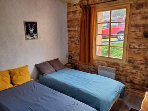 deux lits dans une chambre avec une fenêtre dans l'établissement Le chalet Lili, à Gérardmer