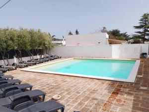 a large swimming pool with chairs around it at La dimora di nonna Giuliana in Ostuni