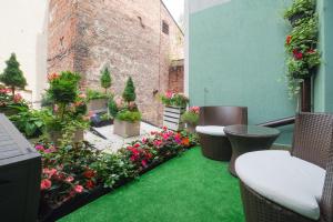 eine Terrasse mit Blumen und Pflanzen auf einem Gebäude in der Unterkunft Green Hostel in Toruń