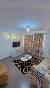 een woonkamer met een bank en een tafel bij Nice cozy 1 bedroom apartment in Ruaka
