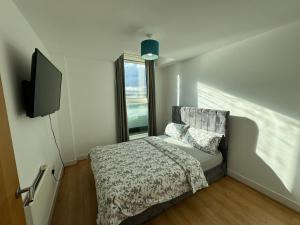 a bedroom with a bed and a tv and a window at Seaside Serenity Haven in London
