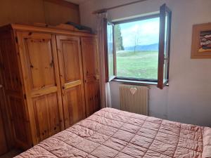 a bedroom with a bed and a window at Casa Costa in Tonezza del Cimone