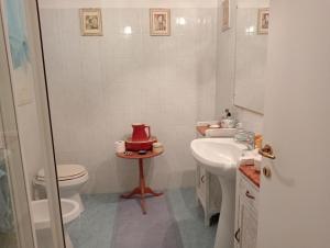 La salle de bains est pourvue de toilettes et d'un lavabo avec un chapeau sur une table. dans l'établissement Alloggio turistico MARBO, à Civitavecchia