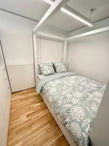 1 dormitorio pequeño con 1 cama y suelo de madera en MydiHei @ Rhyfall Towers, en Neuhausen am Rheinfall