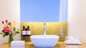 a bathroom with a sink and two bottles of wine at NH Collection Medellin Royal in Medellín