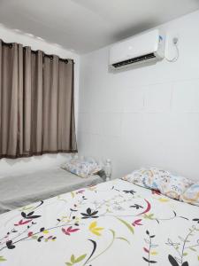 a bedroom with two beds and a window at Porto residence terreo in Porto De Galinhas